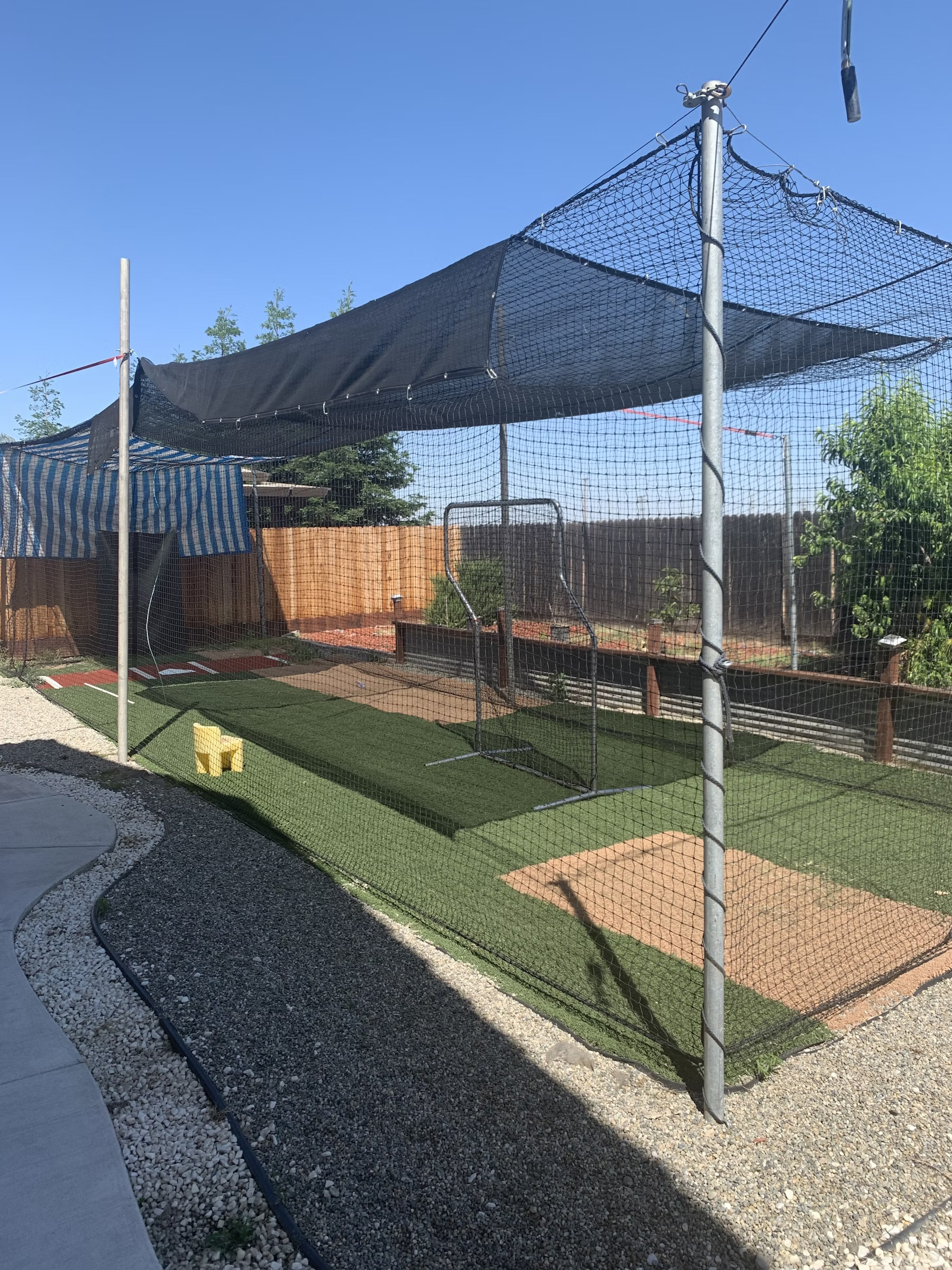 An image of a backyard batting cage showcasing how properly the batting cage poles are anchored